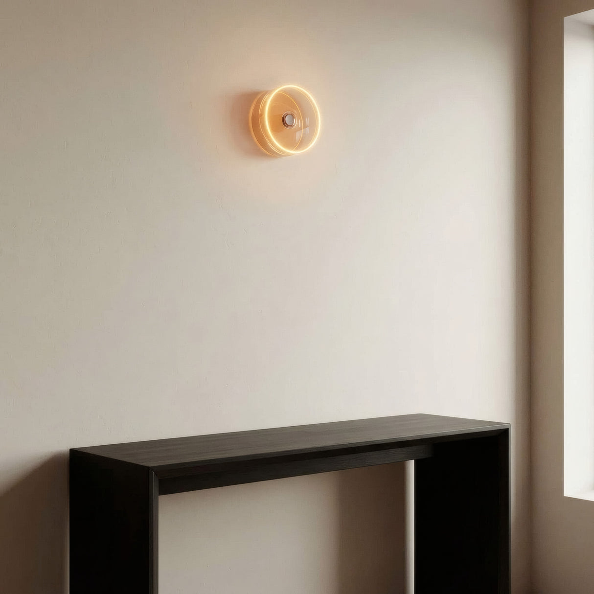 LED-Donut-Lampe E27 aus Rauchglas, Ø 195 mm, eingeschaltet als Wandleuchte in einem reduzierten Wohnzimmer