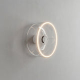 LED-Donut-Lampe E27 aus klarem Glas, Ø 195 mm, eingeschaltet als Wandleuchte in einem reduzierten Interieur